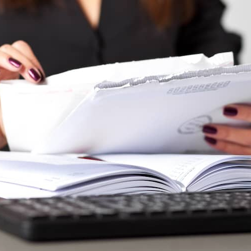 Woman sorting letters at a desk.