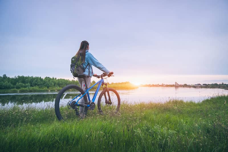 RHB Assets From IGX: Woman biking along river