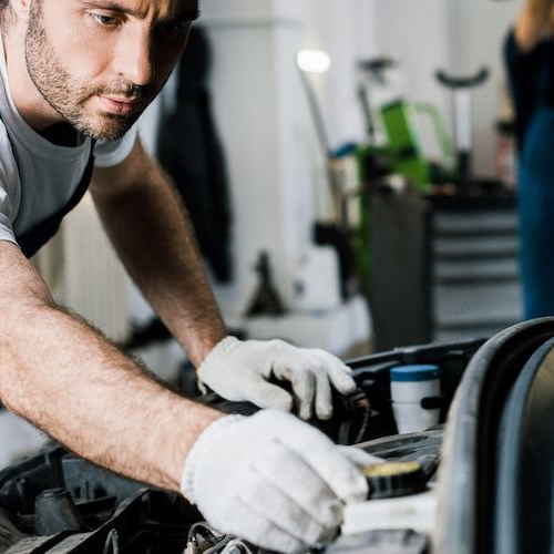 Image of worker repairing car engine.