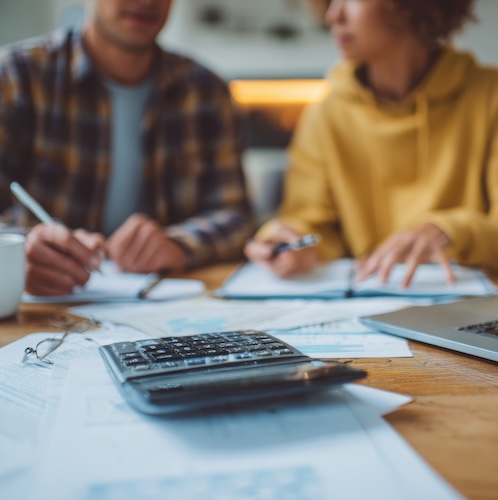 Couple working out their finances at kitchen table.
