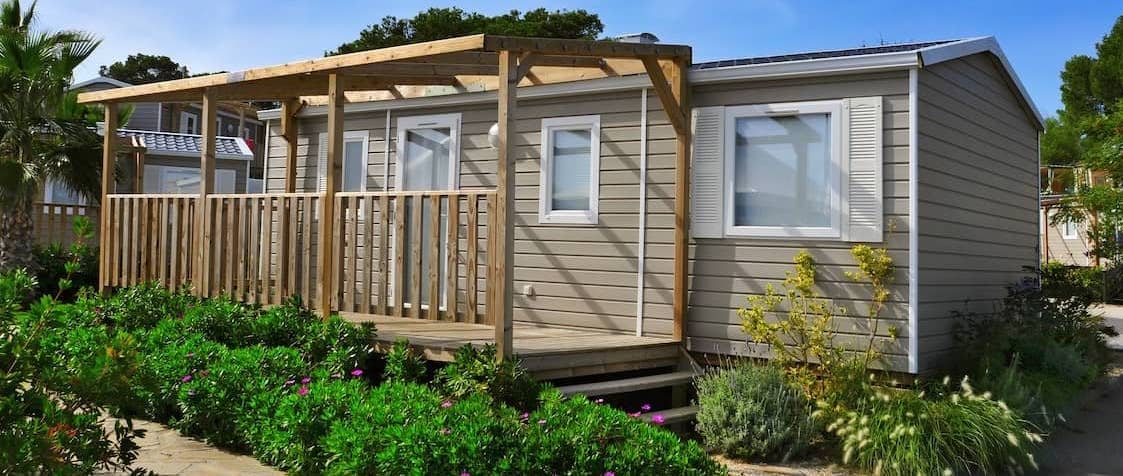 exterior of mobile home with new build on porch and beautiful landscaping