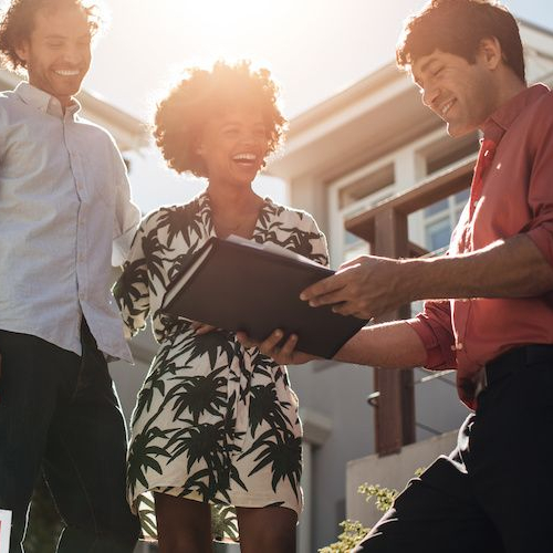 A couple with an agent in a home, likely discussing real estate matters.