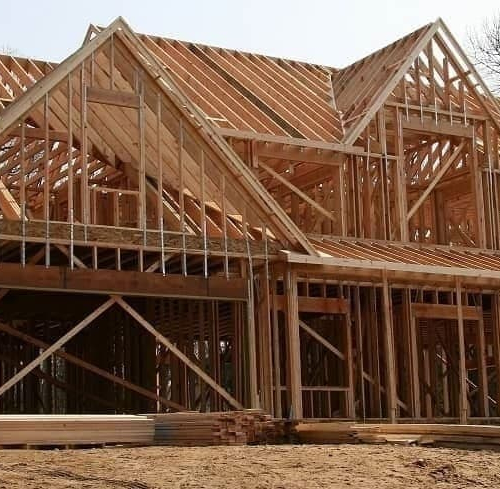 Construction workers building the frame of a new home.