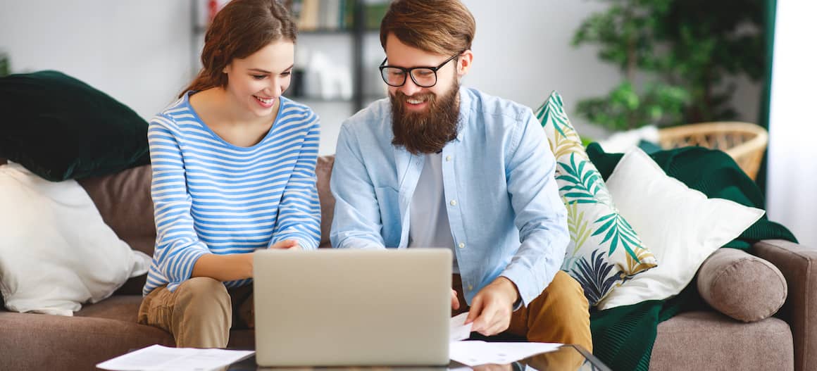 A couple paying their mortgage online using a laptop.