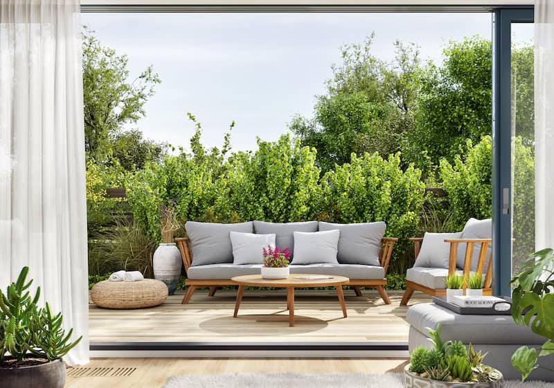 RHB Assets From IGX: Outdoor patio with modern furniture and a lush green backdrop