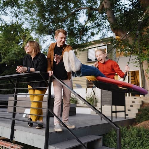 Family spending time together on the deck of their home.