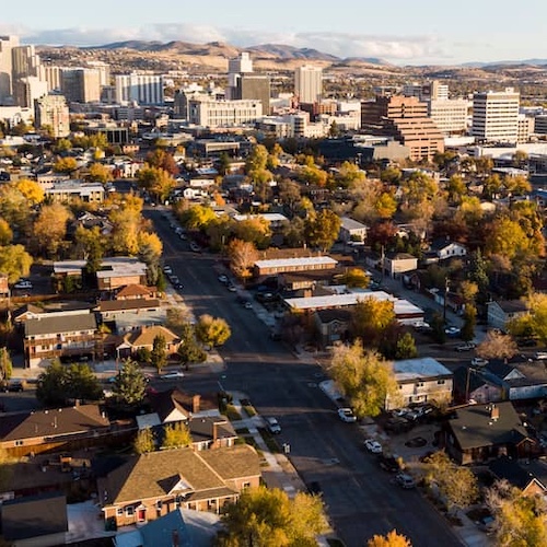 Aerial view of city with mountains in the background.