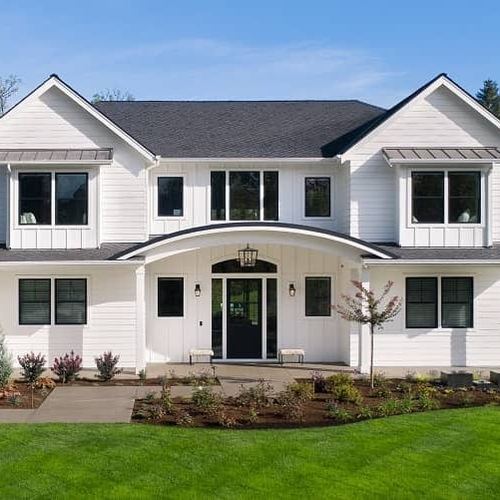 The exterior of a white house during the day, showcasing a residential property.
