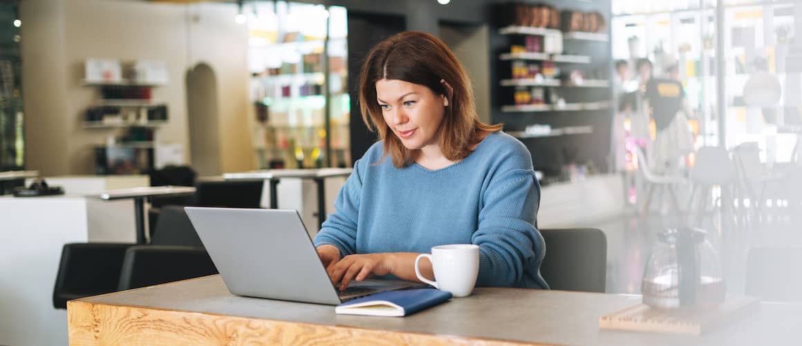 Woman on laptop in cafe.