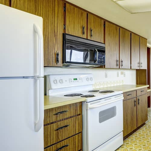 An image of a kitchen with modern appliances in wood style design.