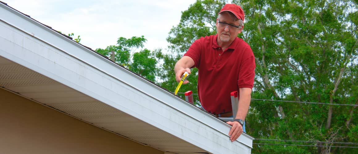 Home inspector on a roof performing an inspection.