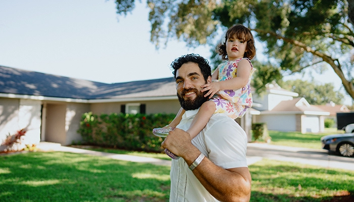 Man holding toddler on his shoulders.