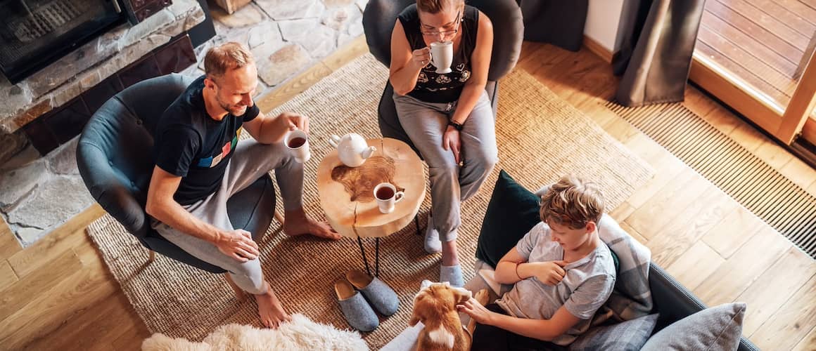 Family hanging out in living room with golden retriever.