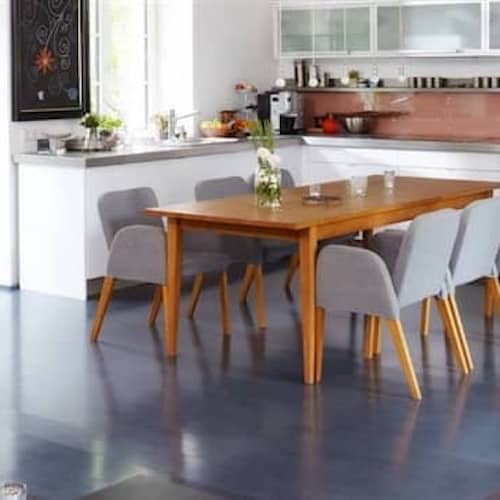 A contemporary kitchen and living room with stylish furniture including a table and chairs.