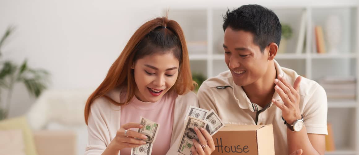 Asian couple saving for vacation, possibly discussing financial plans or budgeting.