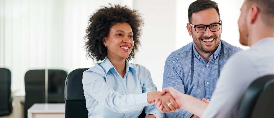 Young woman shaking the hand of a financial advisor.