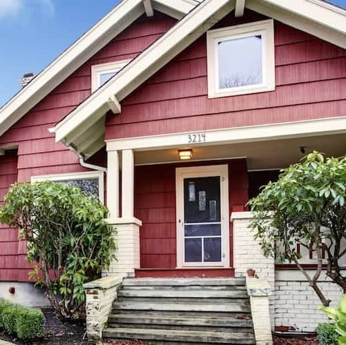 Red bungalow with covered porch.