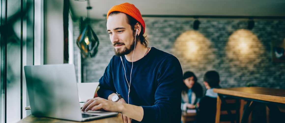 Man on laptop in cafe.