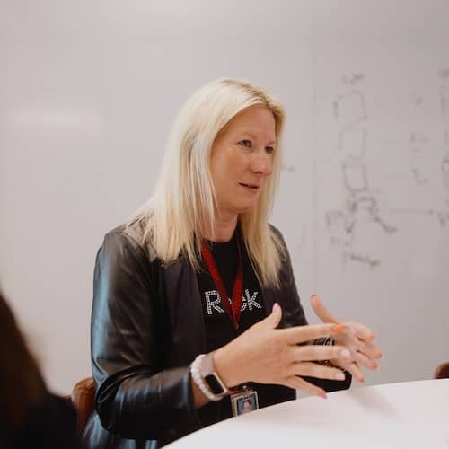 Team member speaking to a group in a conference room.