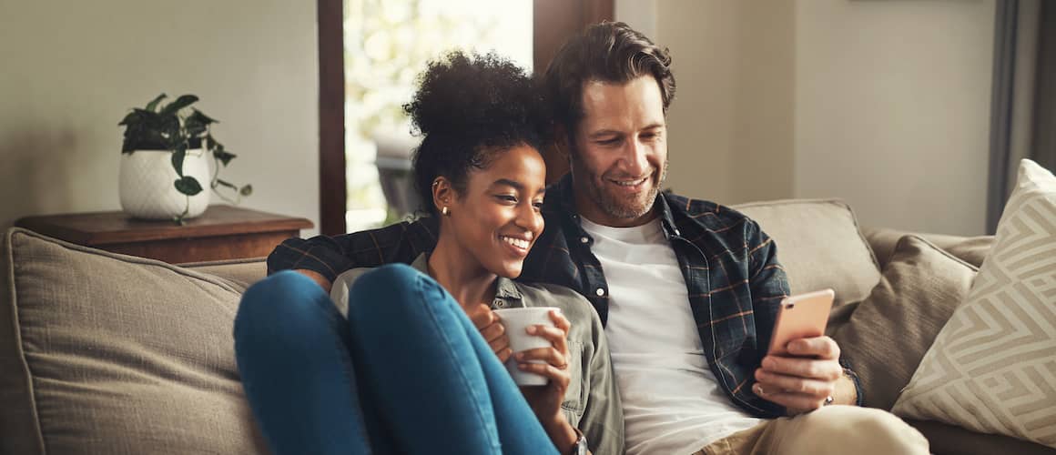 A couple on a couch, possibly discussing or planning their home purchase.