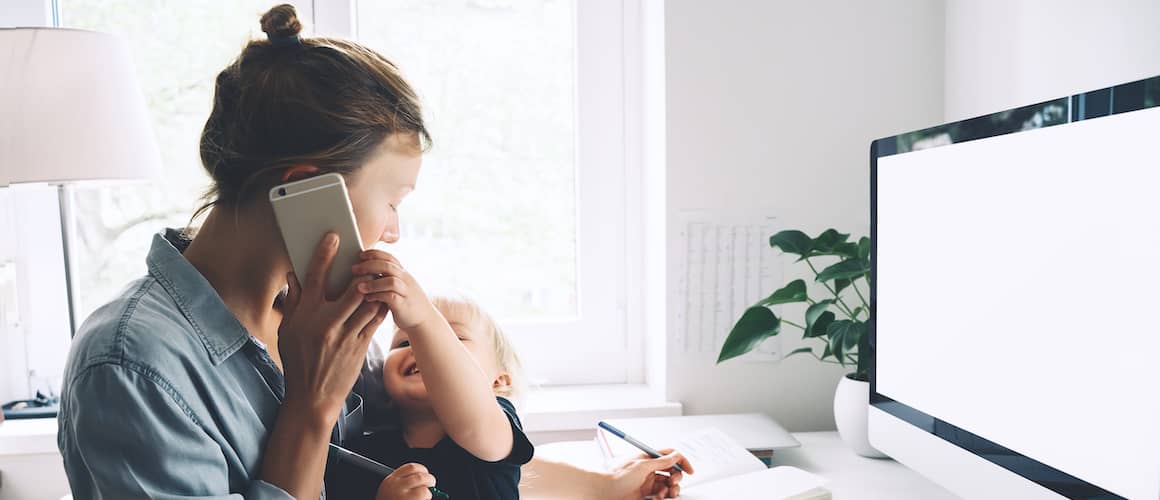 Mother working at home with baby.