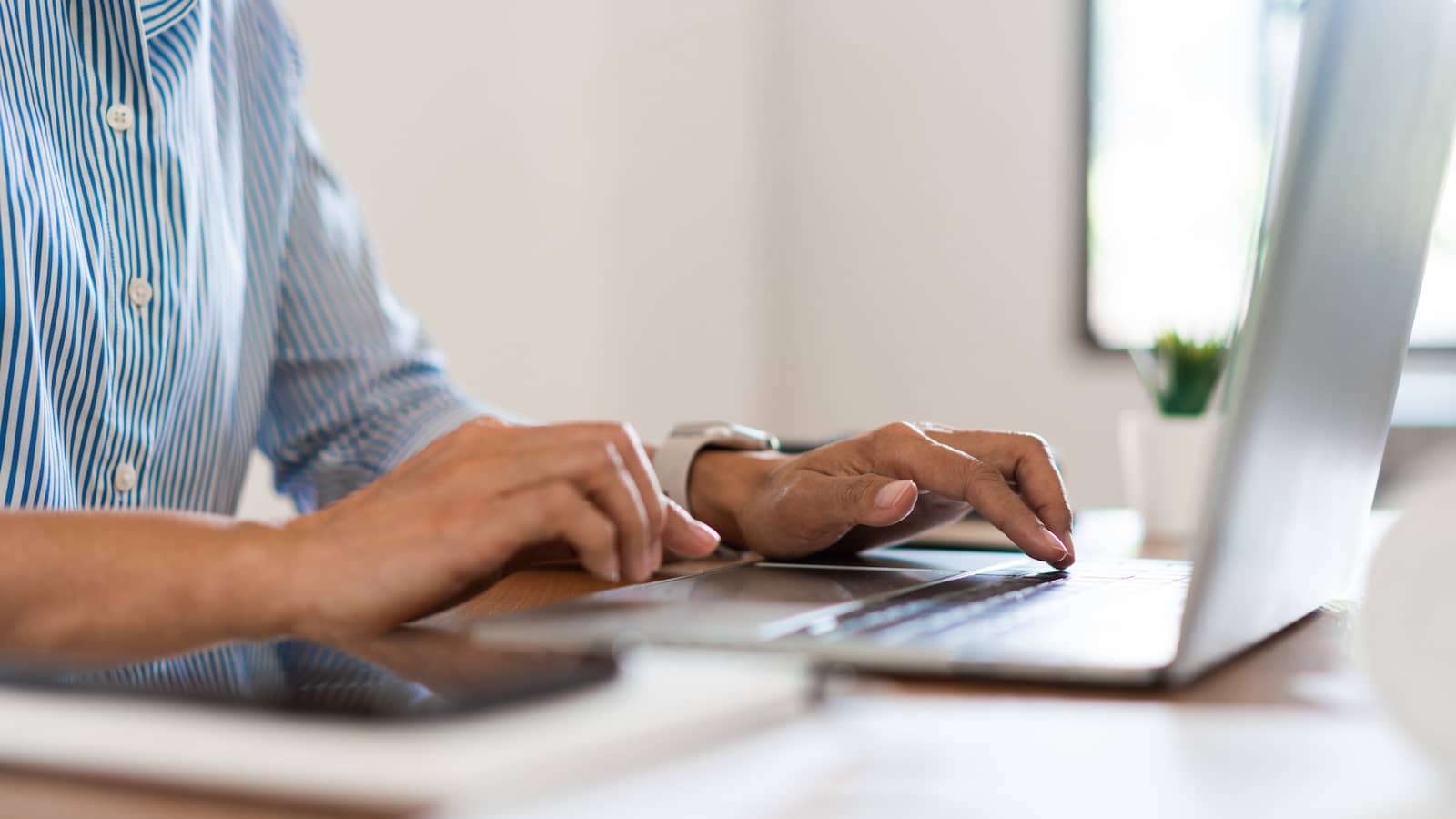 Close up hands of businessman typing on laptop keyboard to working and searching business data