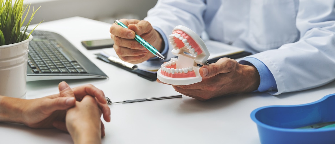 dentist explaining procedure with fake mouth