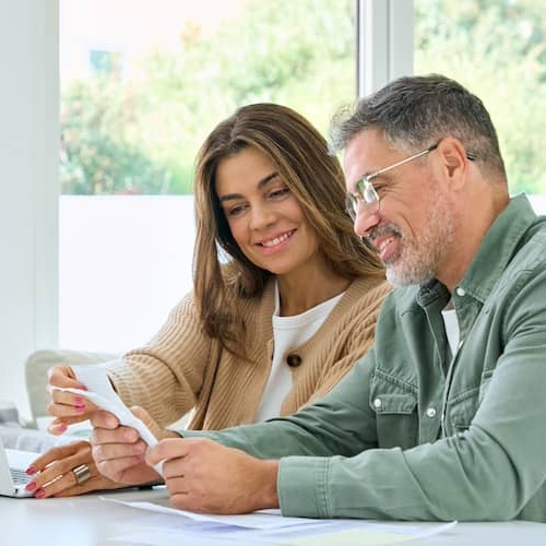 Couple reviewing finances at kitchen island together.