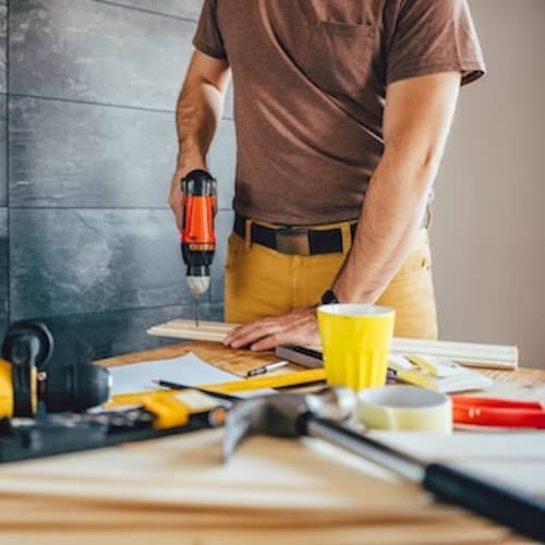 Man using power drill working on home improvement project.