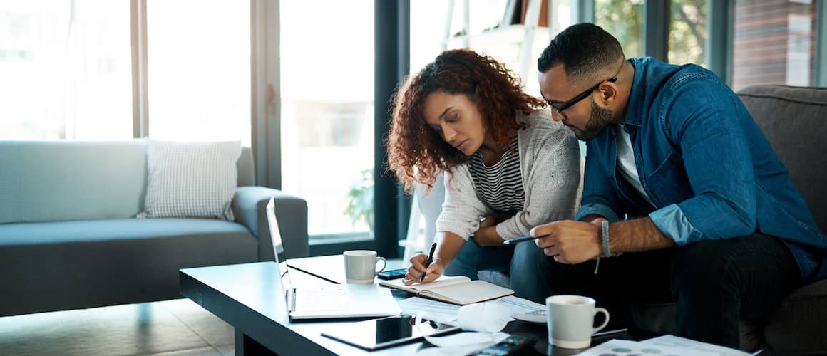 Couple reviewing their shared finances on a coffee table at home.