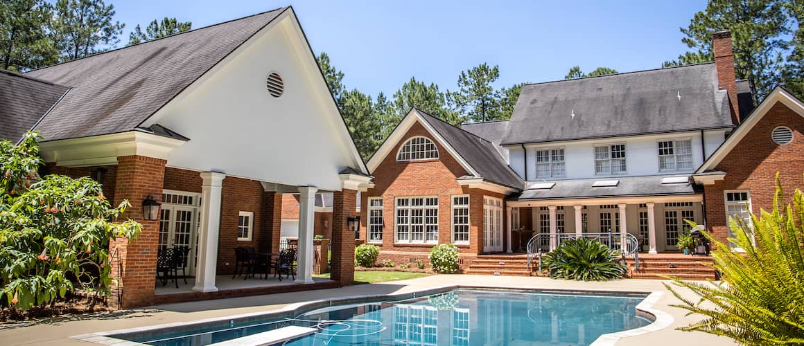 RHB Assets From IGX: A beautiful brick house with a pool and diving board.