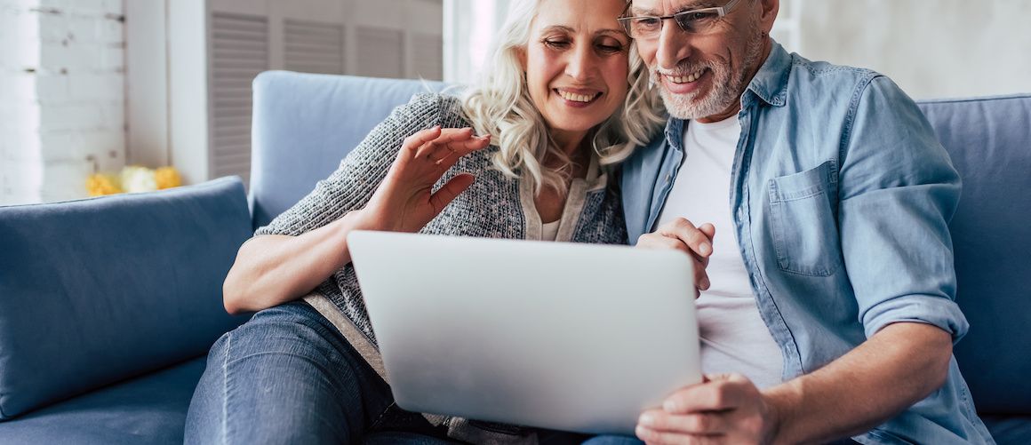 An older couple using a computer, possibly managing financial or home-related matters.