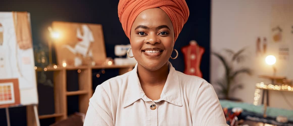 Woman smiling at the camera while standing in her workshop room.