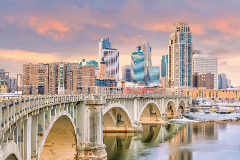 RHB Assets From IGX: Minneapolis cityscape with skyscrapers, waterfront, and a bridge.