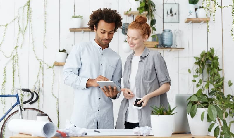 Man helping woman figure out why her card isn't working.