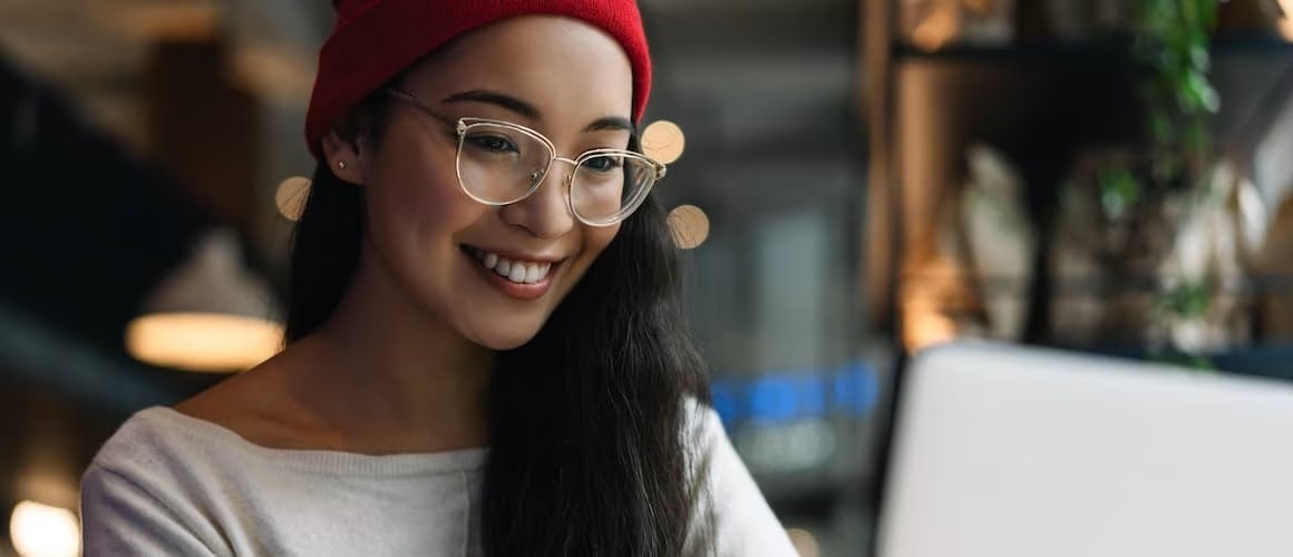 Asian-American woman wearing beanie and smiling.