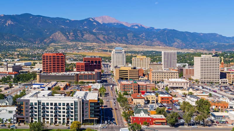 RHB Assets From IGX: Colorado Springs cityscape with mountain views in the background.