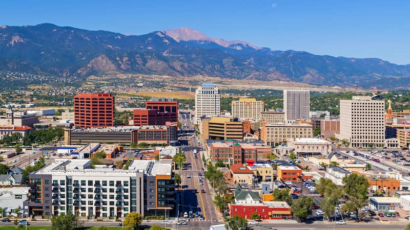 RHB Assets From IGX: Colorado Springs cityscape with mountain views in the background.