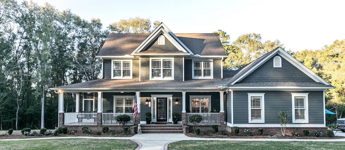 RHB Assets From IGX: Large blue house with a welcoming front porch and white columns.