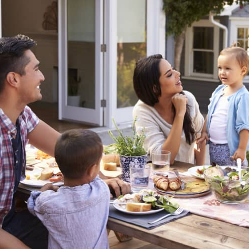 A family having a meal in their backyard.