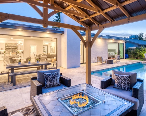 Backyard patio of a home with a firepit and a pool.