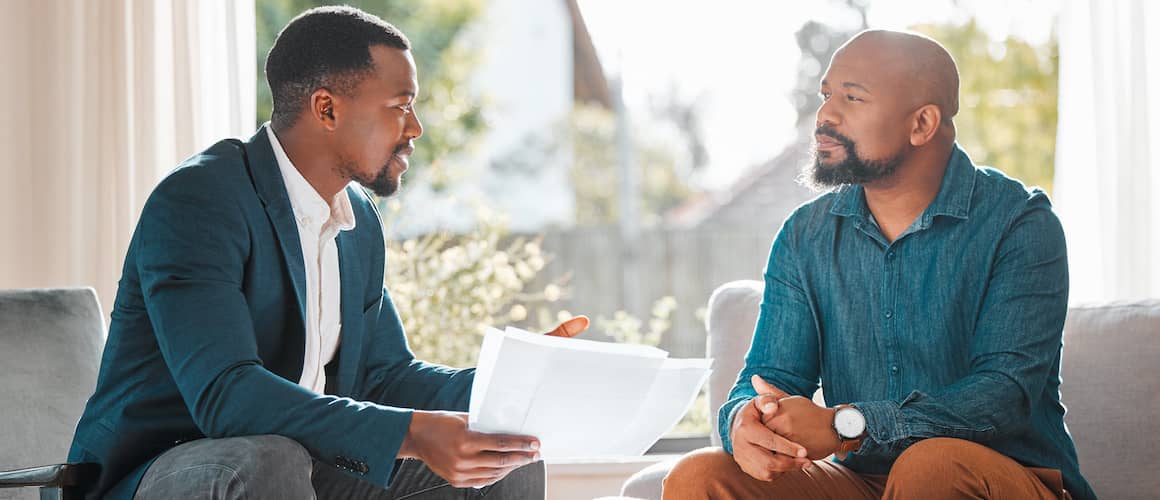 Financial advisor speaking with another man in his home.