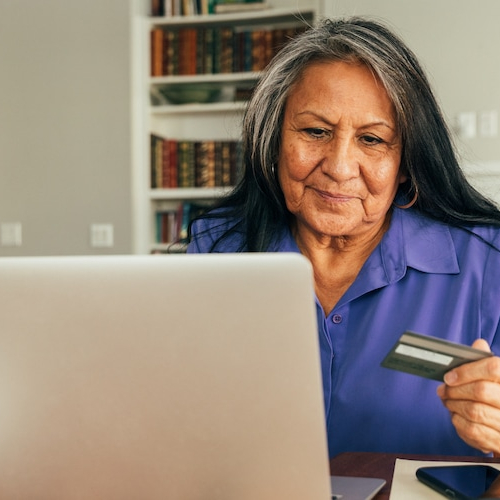 An indigenous woman engaged in the process of checking a credit score or financial information.