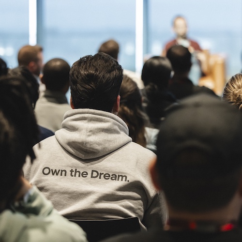 Crown watching speech with the camera focused on a hoodie with the saying "Own the Dream." 