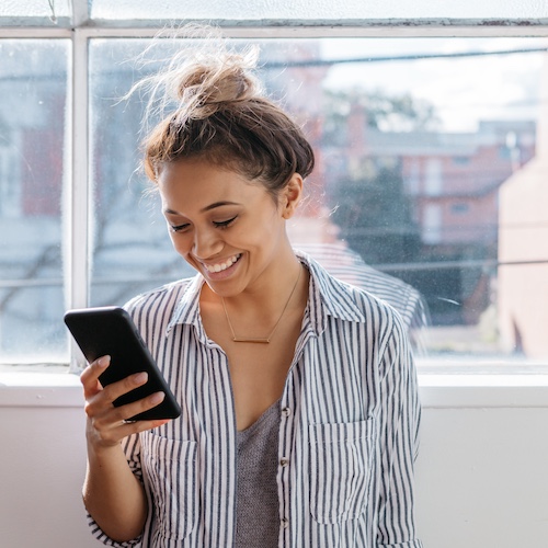 Woman looking at her phone and smiling.