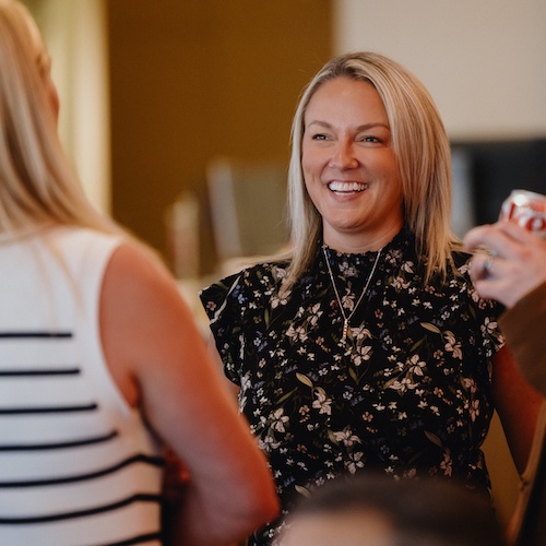 Woman laughing in a group at a gathering.