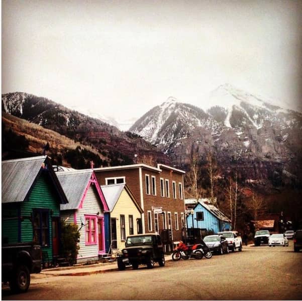 Road in Telluride with small houses and apartments, with mountains in the background.