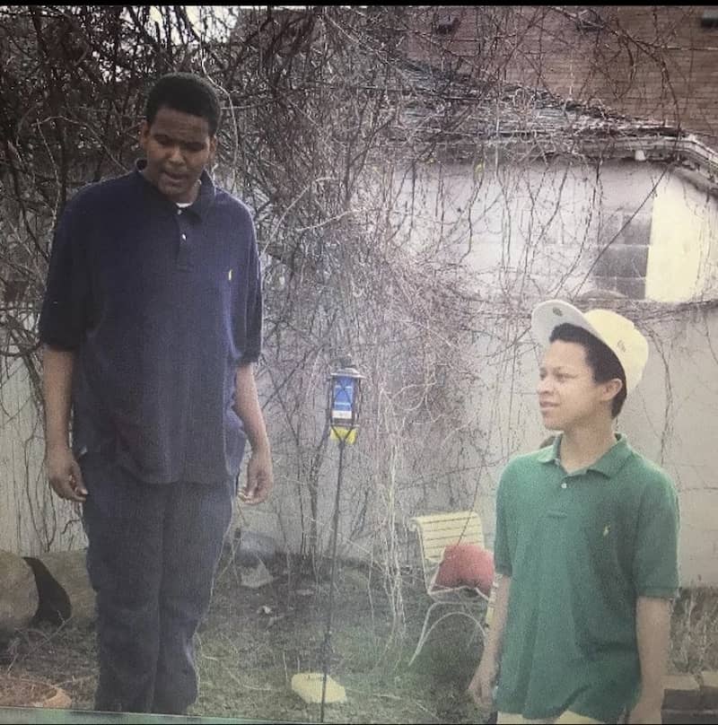 Two young men in front of the Birwood wall.