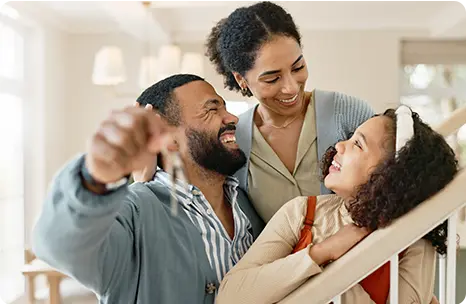 A Black family of three enjoy a moment together celebrating the purchase of their new home.