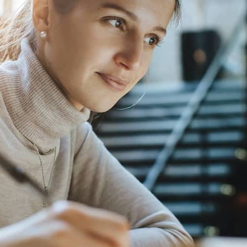 A woman using her personal computer with a satisfactory and a confident look on her face.